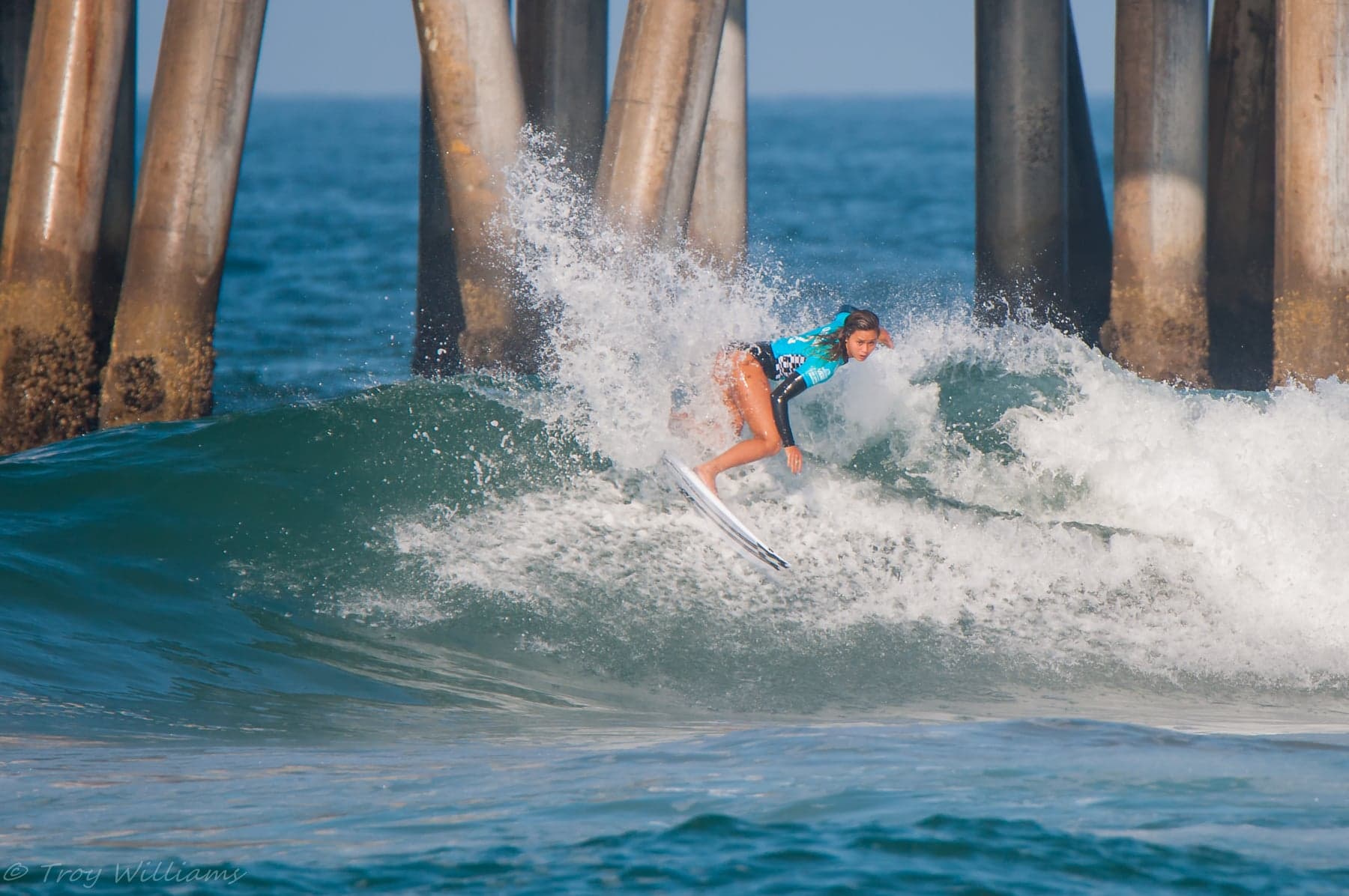 Alessa riding a breaking wave beside Huntington Beach pier. Example photography by Troy Williams.